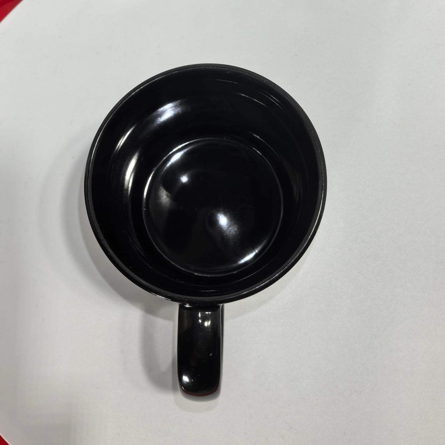 Innenansicht schwarze Keramiktasse glänzend leer.