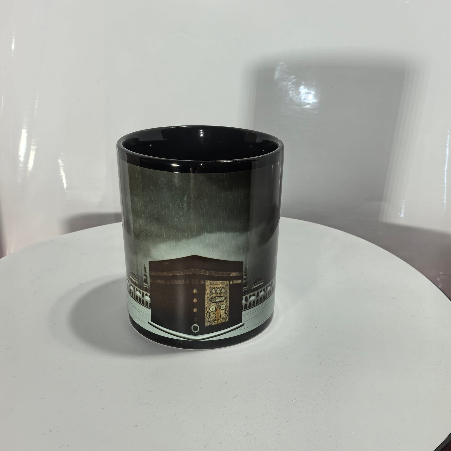 Schwarze Kaffeetasse mit goldenem Kaaba Motiv Mekka Panorama.