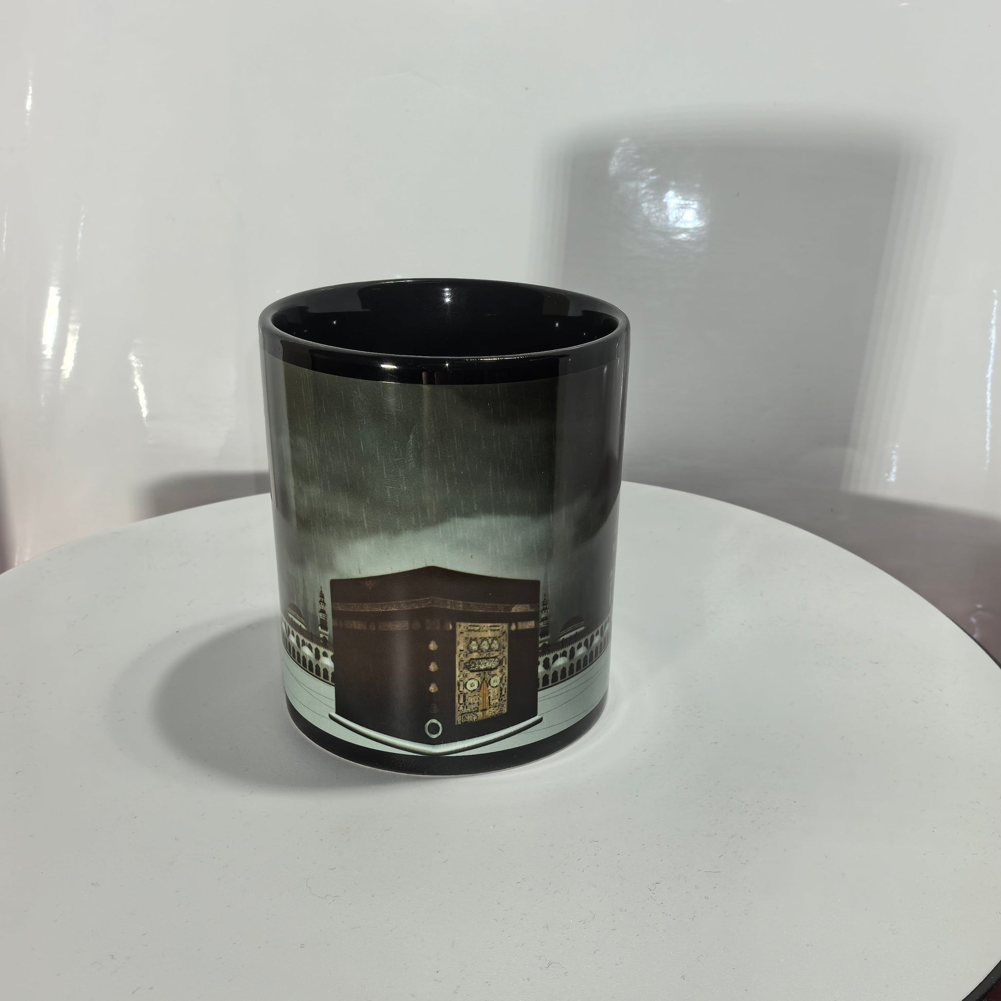 Schwarze Kaffeetasse mit goldenem Kaaba Motiv Mekka Panorama.