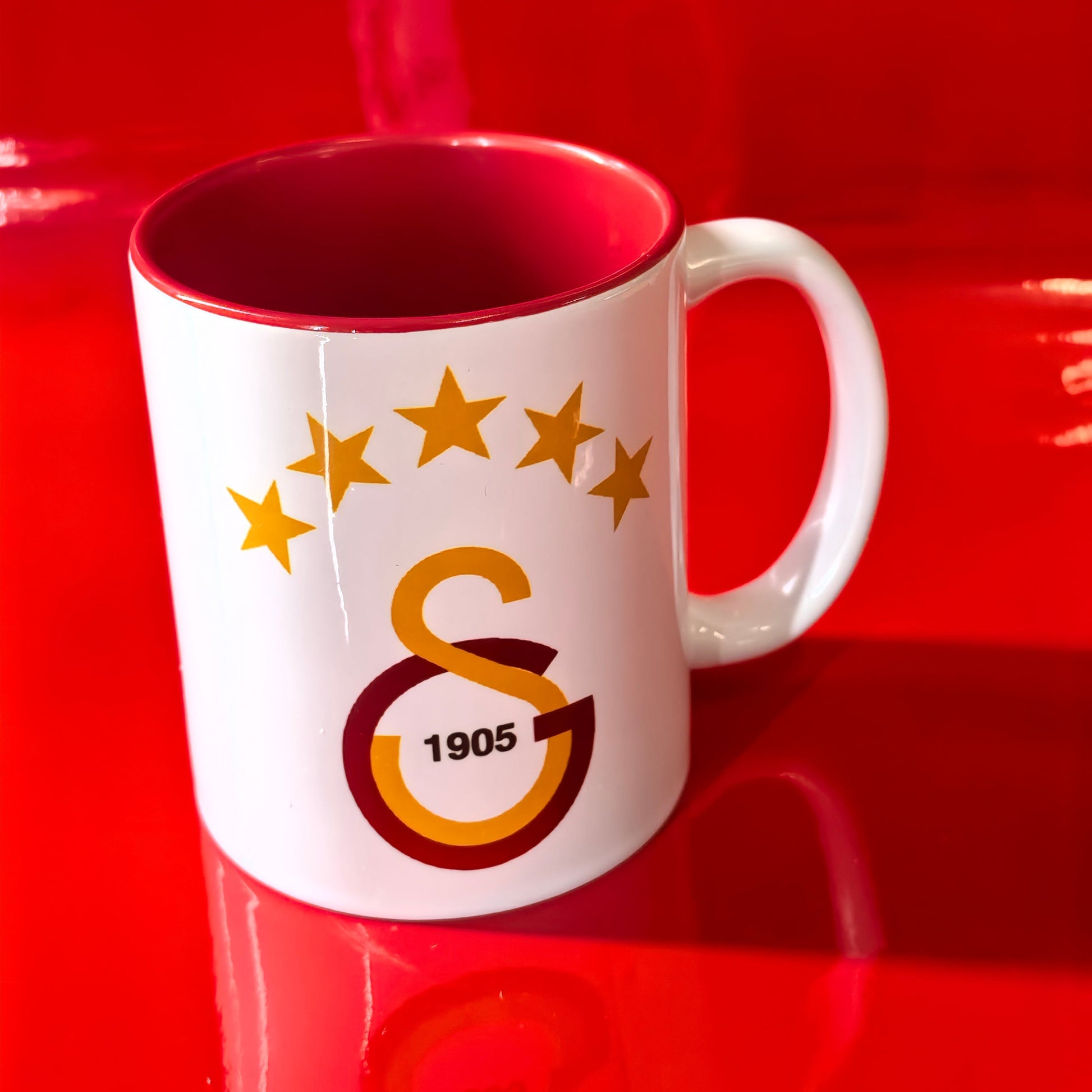 Galatasaray Tasse Logo mit GS 1905 Emblem und 5 Sternen auf rotem Hintergrund.