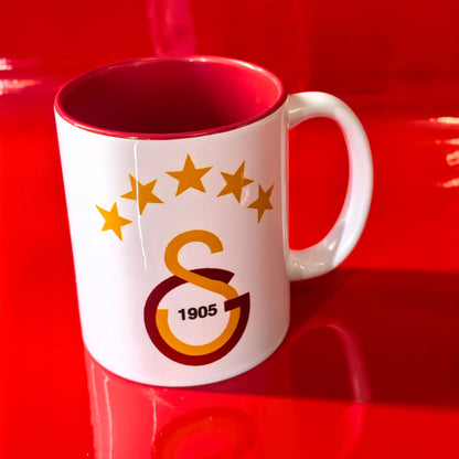 Galatasaray Tasse Logo mit GS 1905 Emblem und 5 Sternen auf rotem Hintergrund.
