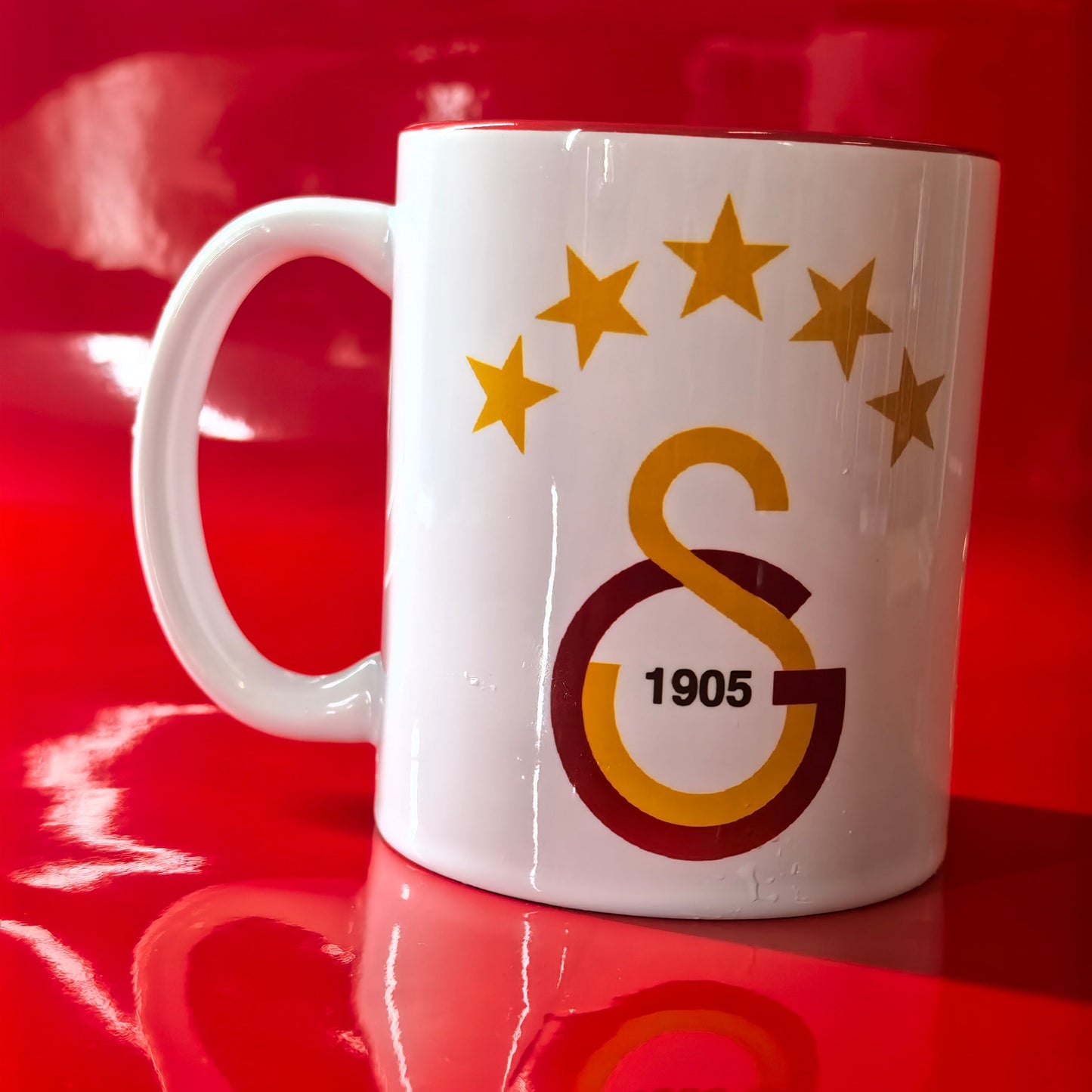 Galatasaray Tasse Logo mit GS 1905 Emblem und 5 Sternen auf rotem Hintergrund.