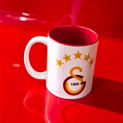 Galatasaray Tasse Logo mit GS 1905 Emblem und 4 Sternen auf rotem Hintergrund.