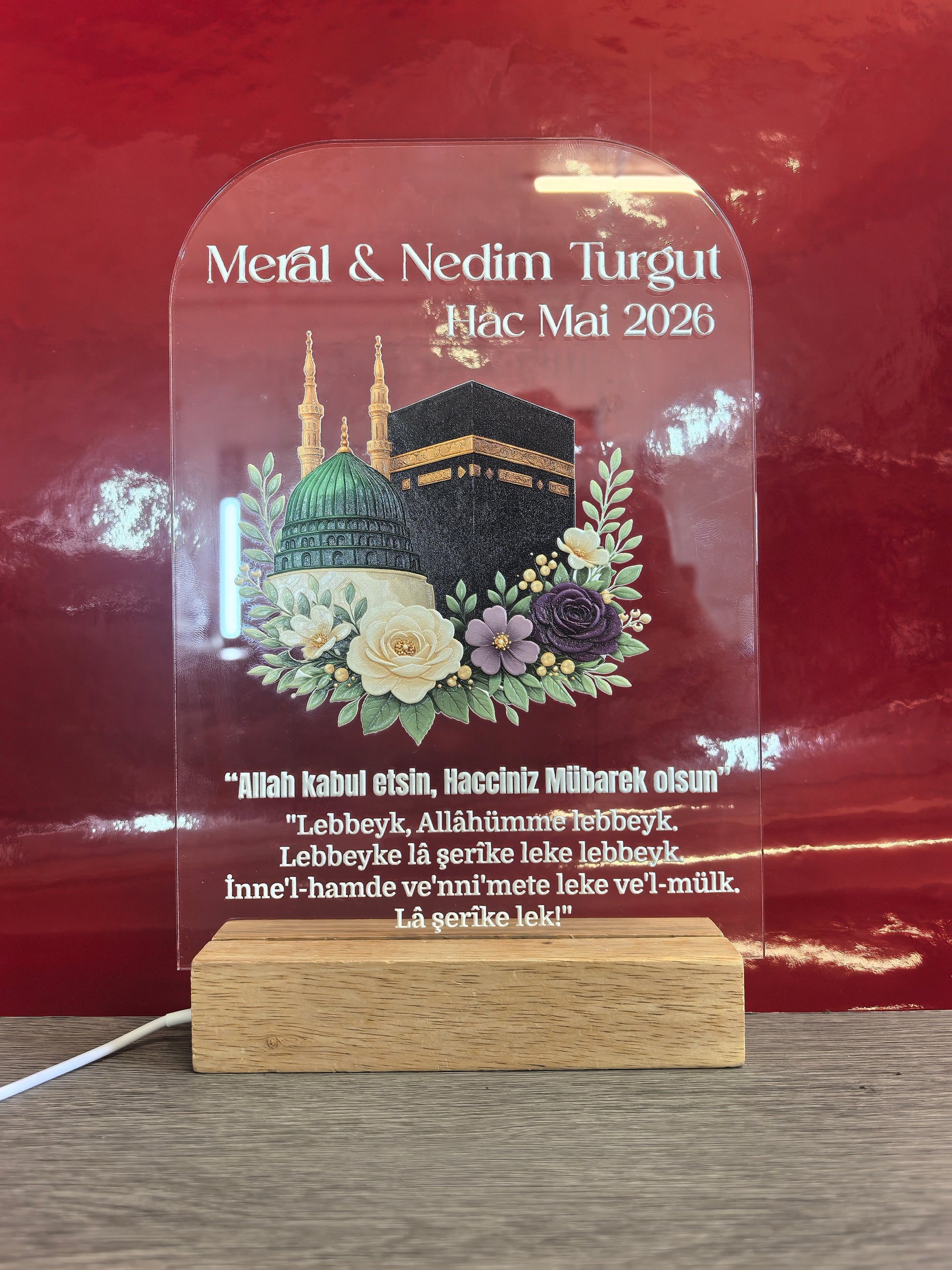Personalisiertes Pilgerfahrt Acrylglas Gesamtansicht mit Kaaba-Motiv, Blumen, Namen und islamischem Gebet auf LED-Holzsockel, roter Hintergrund