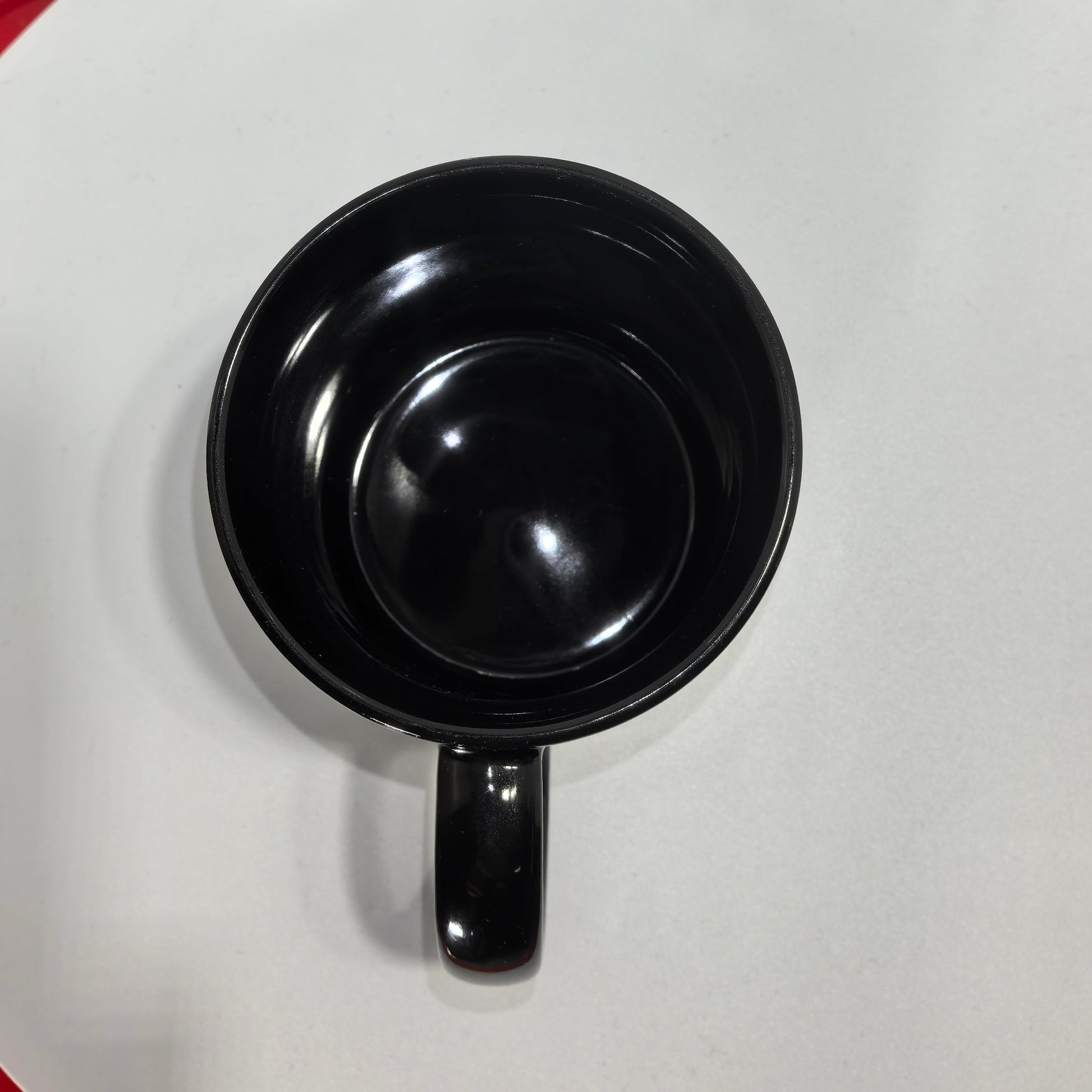 Innenansicht schwarze Keramiktasse glänzend leer.