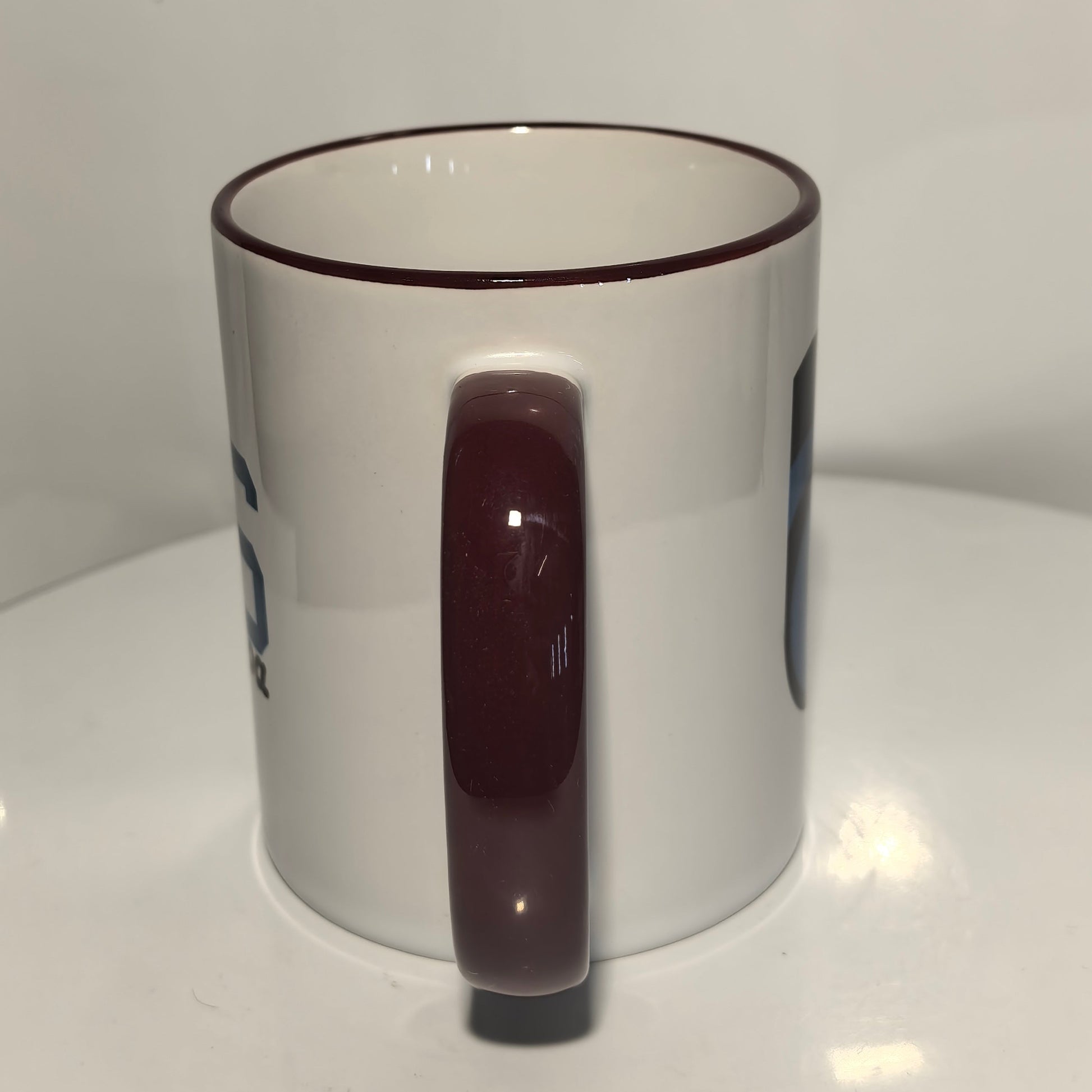 Rückseite: Trabzonspor Fan-Tasse Rückseite – weißer Keramikbecher mit bordeauxrotem Henkel, Seitenansicht