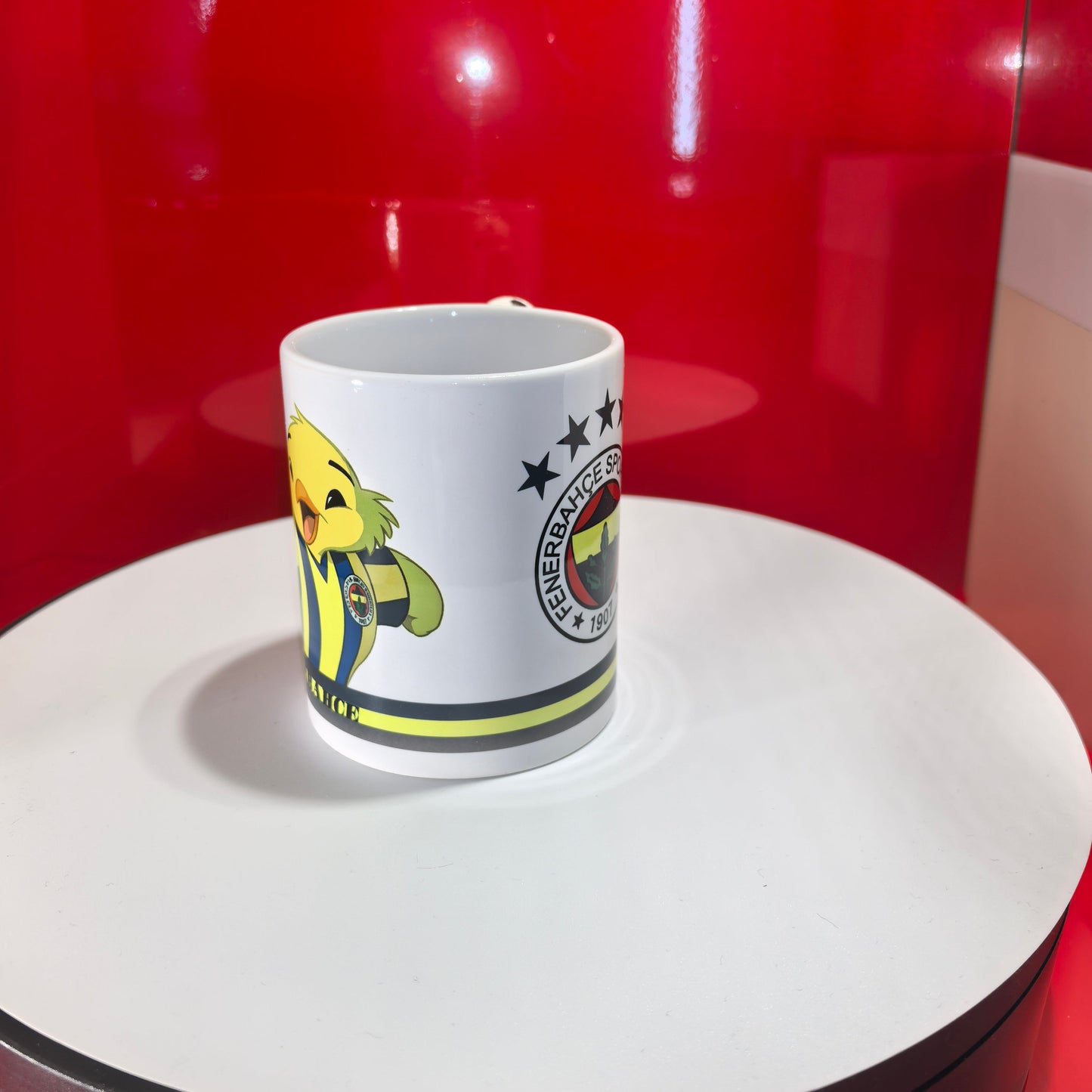 Seitenansicht der Fenerbahçe Tasse, die das Kanarya-Maskottchen in den Vereinsfarben zeigt.