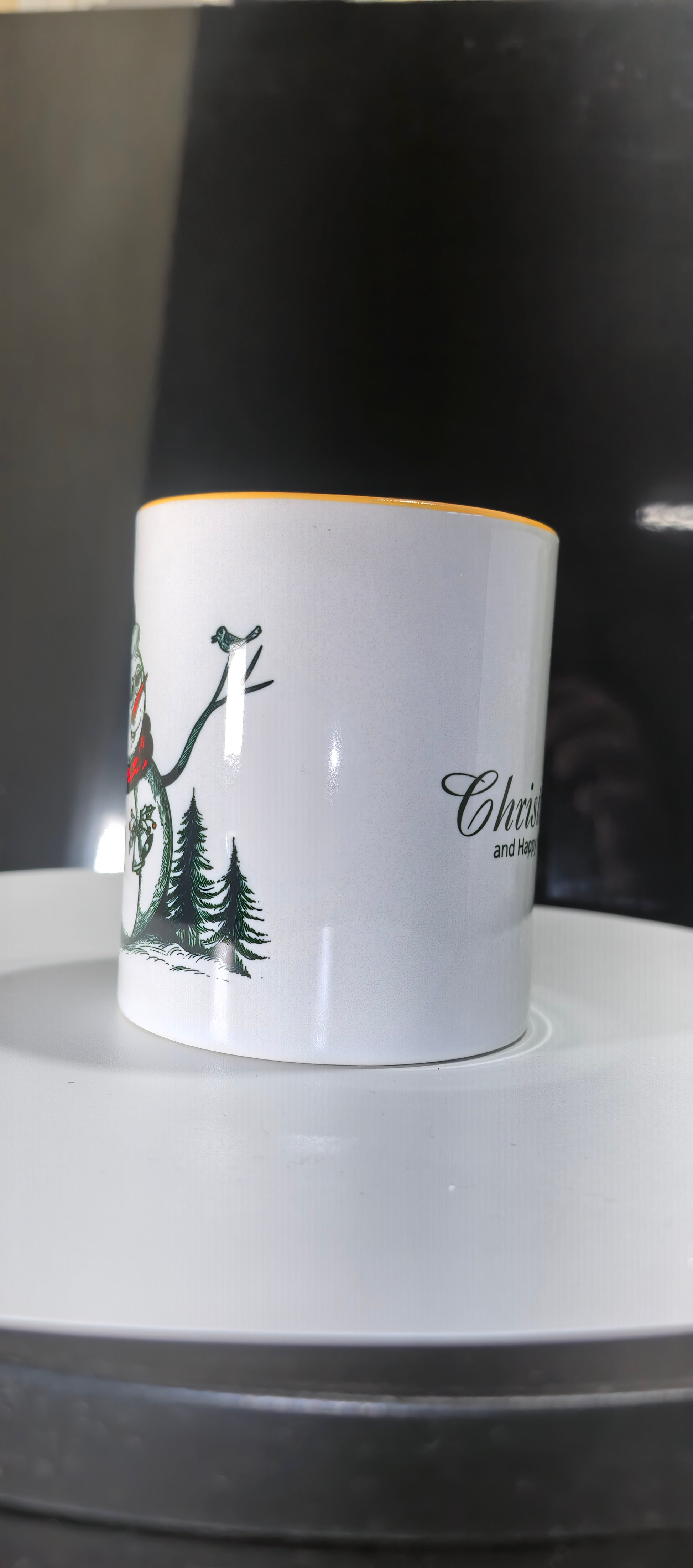 Seitenansicht der Tasse mit Schneemannmotiv und Tannenbäumen.