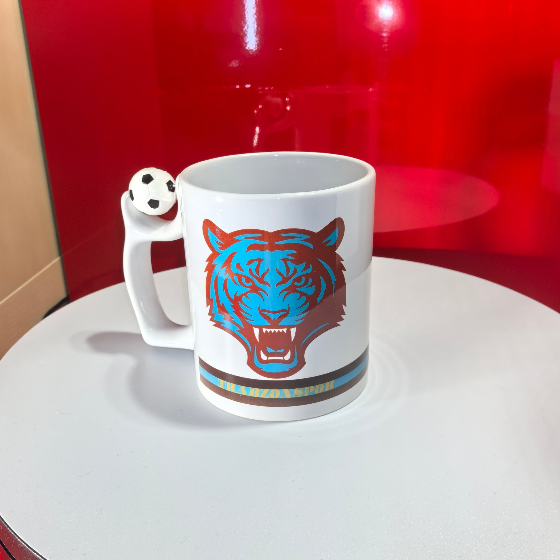 Weiße Trabzonspor-Tasse mit aggressivem, stilisiertem Tiger-Motiv in Türkis und Braun.