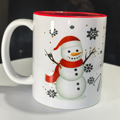 Weihnachtstasse Schneemann mit rotem Schal und Schneeflocken auf weißem Hintergrund.
