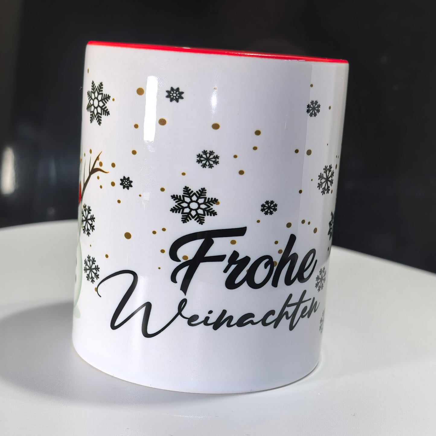 Detailansicht der Weihnachtstasse mit "Frohe Weihnachten"-Schriftzug und Schneeflocken.