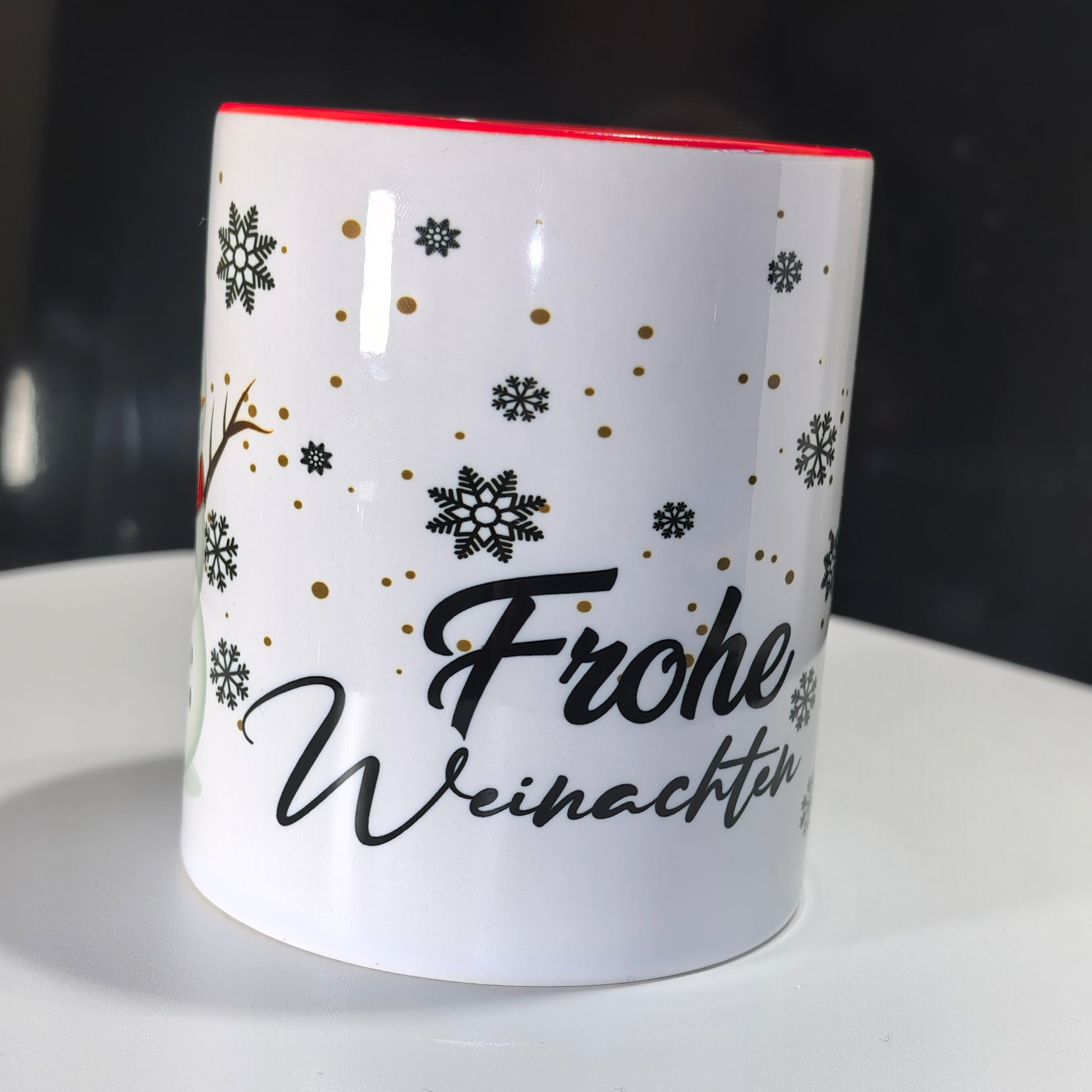 Detailansicht der Weihnachtstasse mit "Frohe Weihnachten"-Schriftzug und Schneeflocken.