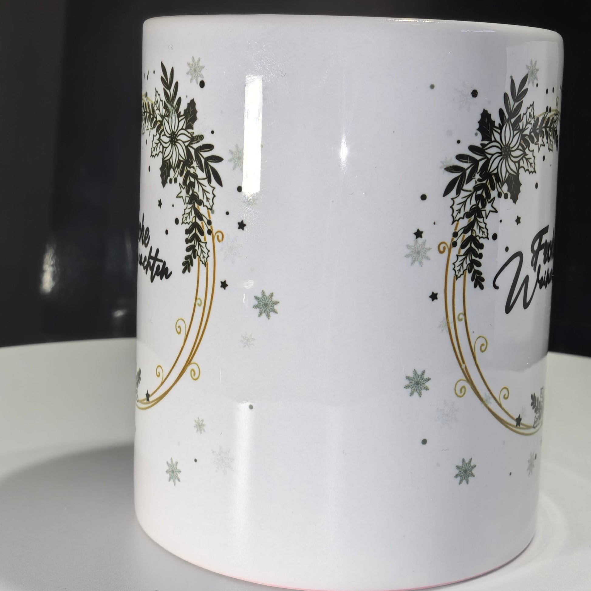 Weihnachtstasse mit elegantem grünem Kranz, Goldrand und "Frohe Weihnachten" auf weißem Hintergrund.