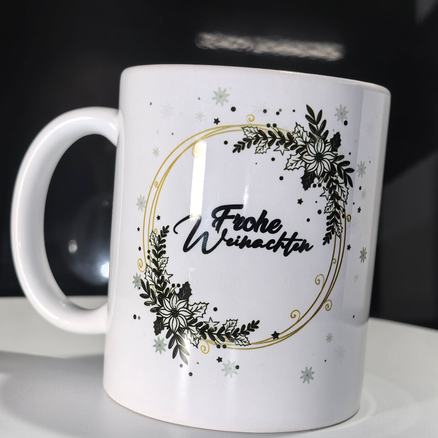 Weihnachtstasse mit grünem Kranz, Goldrand und "Frohe Weihnachten"-Schriftzug.