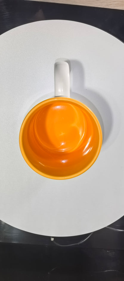 Blick in die leuchtend Goldgelb Farbene Innenseite der lustigen Schneemann Tasse.