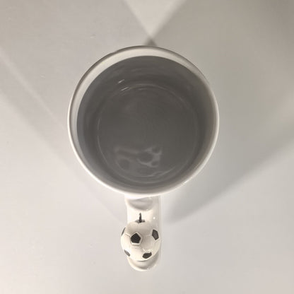 Blick in die graue Innenseite der Fußball Tasse mit Fußball-Henkel.